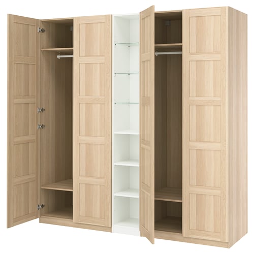 An IKEA PAX wardrobe in white with doors open, revealing shelves and hanging space. Light wood finish, rectangular shape, panel design.