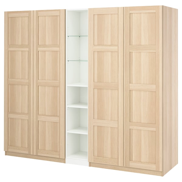 Displays an IKEA PAX wardrobe in light oak with four doors and an open compartment, crafted from particleboard and fiberboard with a wood finish.