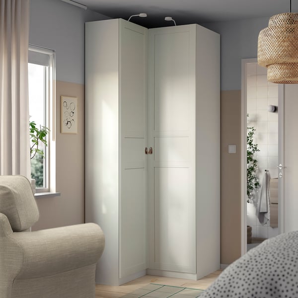 White IKEA PAX corner wardrobe in rooms corner, matching minimalist decor.