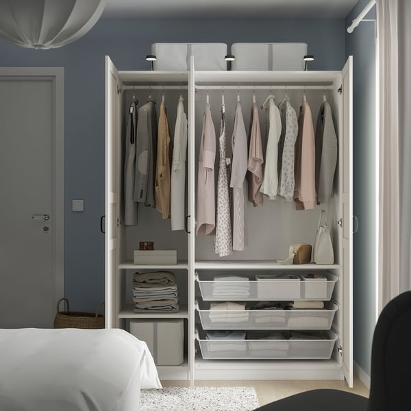 Open wardrobe displaying clothes, shelves, and storage baskets in a bedroom.