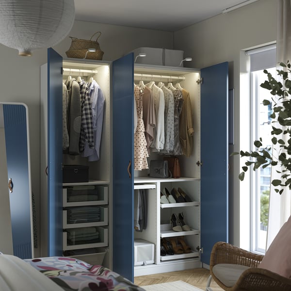 Blue wardrobe, open, reveals organised clothing. Hangable storage, shelves, led light, and shoe racks visible.