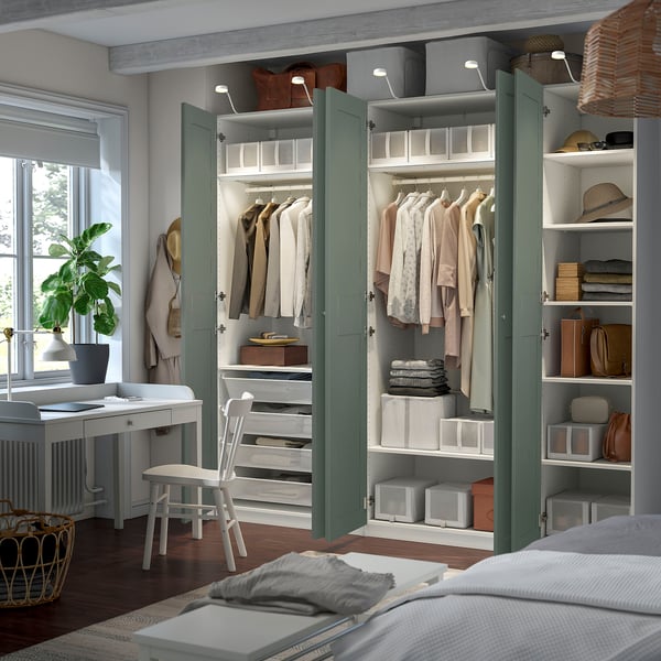A well-organized room with a large wardrobe displaying clothes, shelves, and storage boxes. The wardrobe foldable shelves and internal lights.