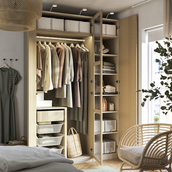 Wooden wardrobe with open door showing clothes and organised storage.
