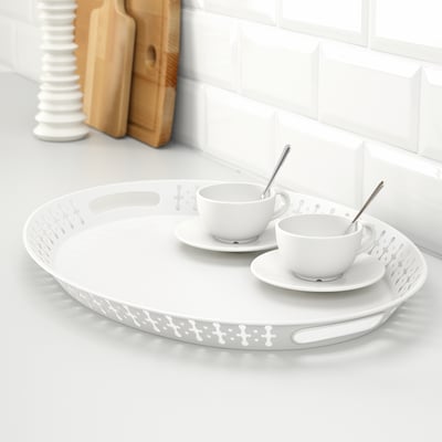 White decorative tray with handles holds two coffee cups and saucers.