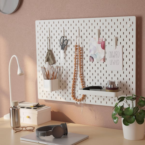 White SKÅDIS pegboard organises office supplies, decorations, and hangs items efficiently.