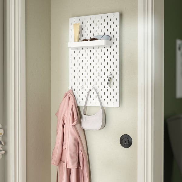 White SKÅDIS pegboard organiser with accessories: shelf, hooks, coat, bag, and keys.