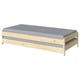 A UTÅKER light wooden bed with a grey mattress. Its rectangular, designed for compact spaces, and stackable for versatility.