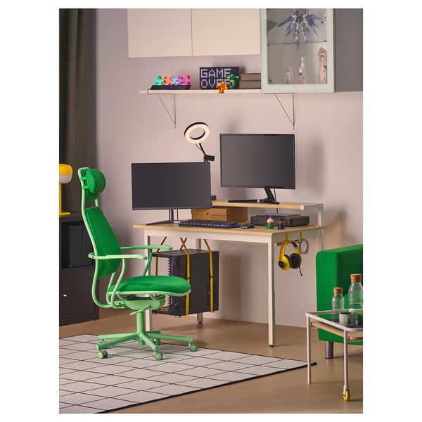 Modern green gaming desk setup with adjustable chair, monitors, keyboard, and headphones. Organised with shelves and cable management.