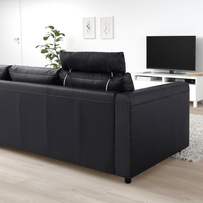 A black VIMLE sectional sofa with square pillow pillars, sleek design for minimalist living room with tv and plant.