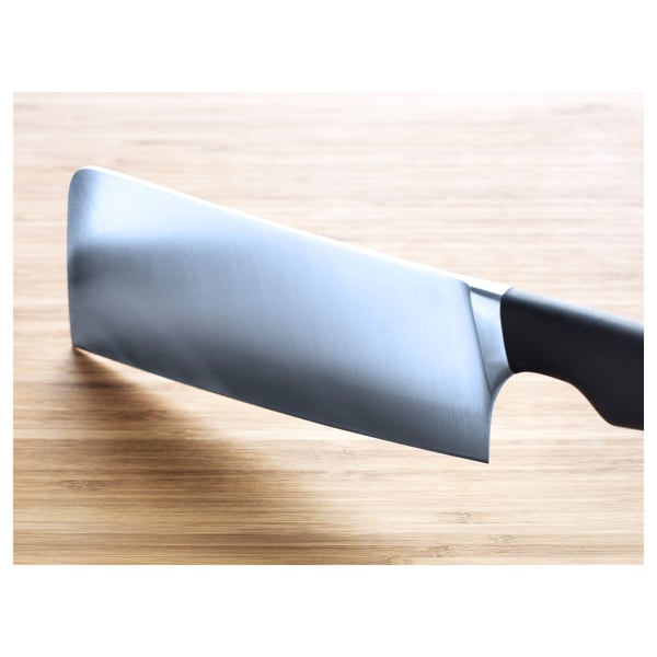 A close-up of a sharp knife on a wooden surface. Its sleek, stainless-steel blade and ergonomic handle emphasises quality and precision.