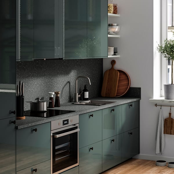 Бирюзовая кухонная столешница, раковина, духовка, темная техника, декор из дерева.