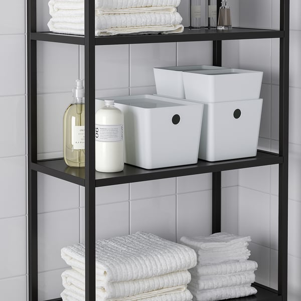 Металлическая полка в ванной комнате с коробками KUGGIS, сложенными полотенцами и аккуратно организованными бутылками.