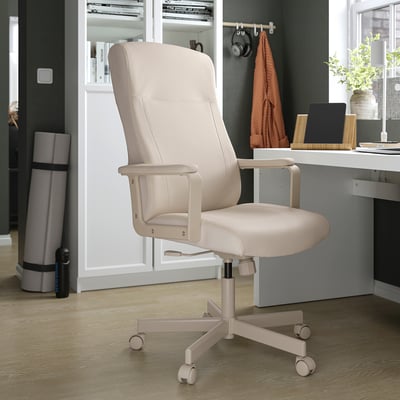 Бежевое настольное кресло MILLBERGET с подлокотниками и колесиками в уютной обстановке домашнего офиса.