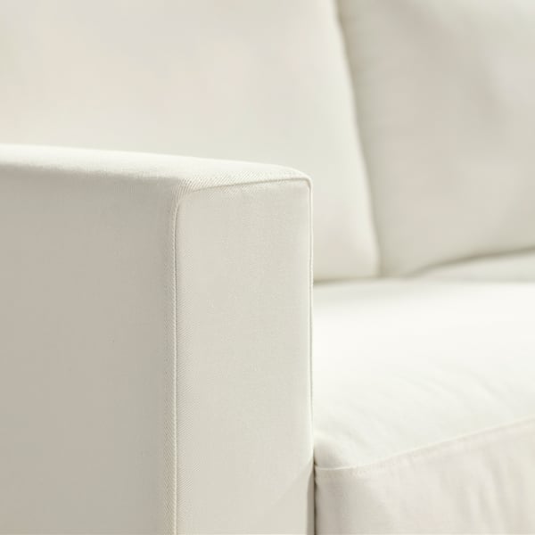 Крупный план белого подлокотника дивана, демонстрирующий аккуратную строчку и мягкую текстуру, подчёркивая качество и комфорт.