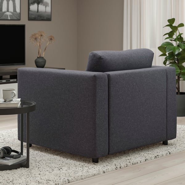 Серый стул VIMLE с подушкой и приставной столик с кружкой и цветами.