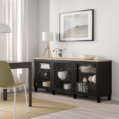 Modern room with BESTÅ sideboard, plates, lamp, plant, photo frame, curtains.