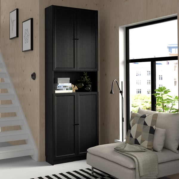Modern living room with BILLY bookcase, colourful sofa, and large window.