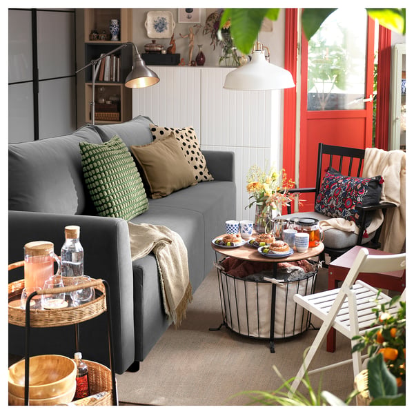 Modern living room with grey BRISSUND sofa, wooden tables, patterned pillows, and cosy decor.