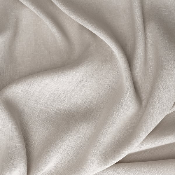 Soft, slightly textured beige linen fabric, folded and draped, allowing light to philtre through.