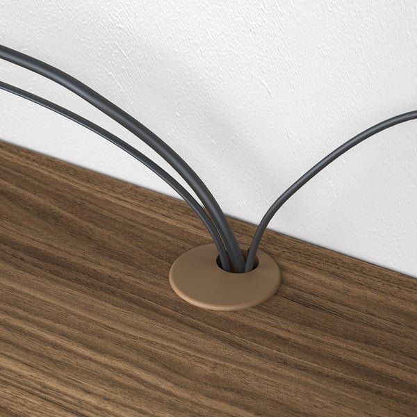 A wooden shelf with a cable management system, featuring two black cords neatly organised and emerging from a central round hole.