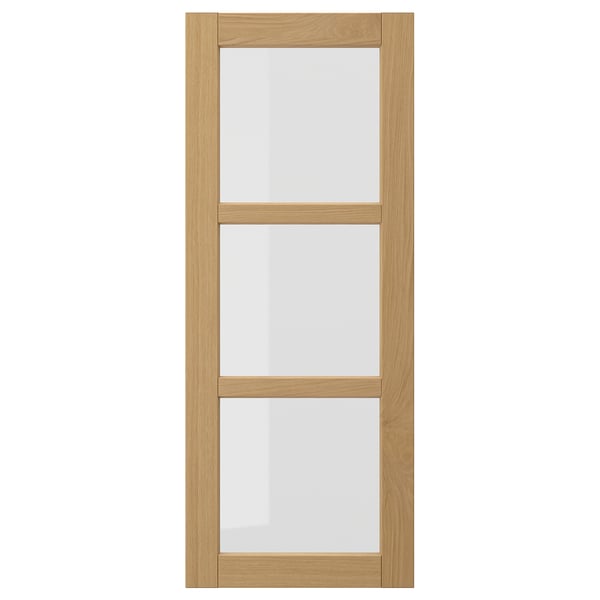 The FORSBACKA kitchen cabinet a warm oak finish with glass doors framed in bevelled edges, exuding a classic, traditional style.