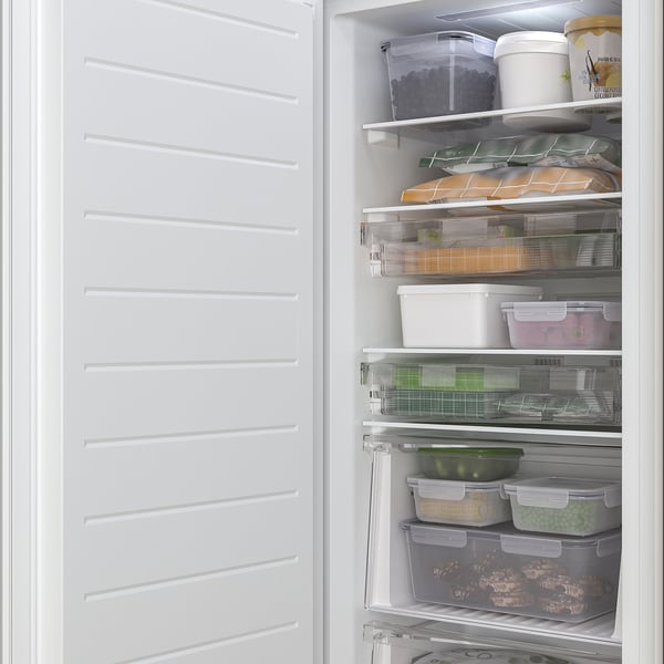 Open freezer with adjustable shelves and drawers, holding frozen food.