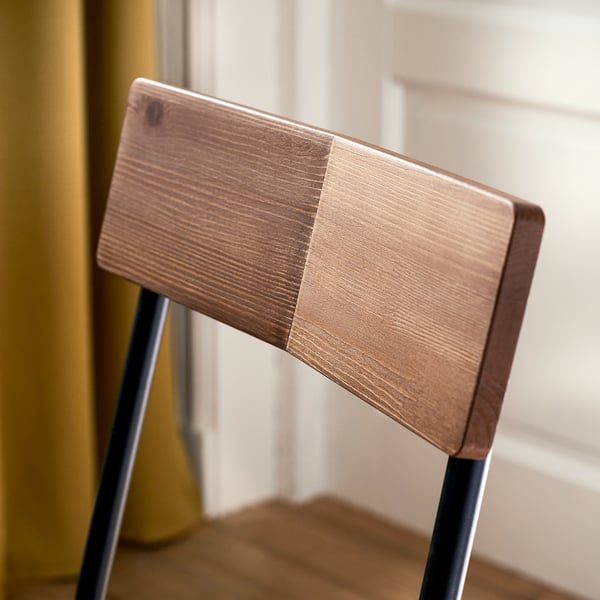 Wooden chair backrest with metal legs, showcasing quality craftsmanship.