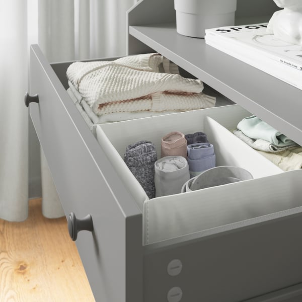Organised dresser drawer with neatly folded clothes in a modern bedroom.