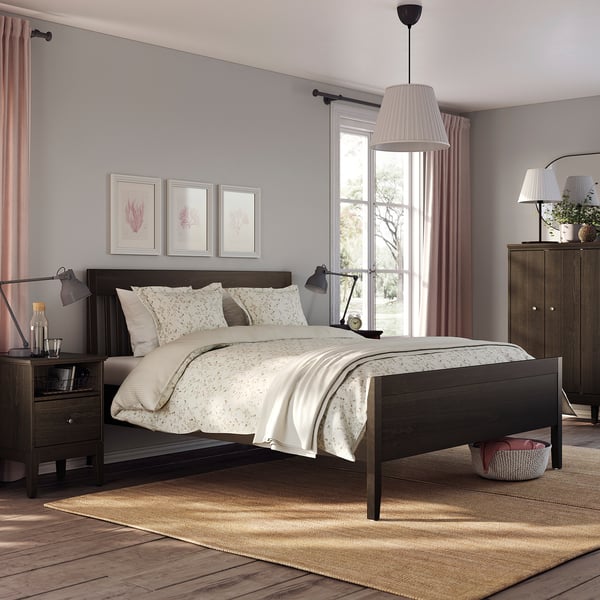 Modern bedroom IDANÄS dark-brown bed with white bedding, wooden nightstands, lamps, and large window with curtains.