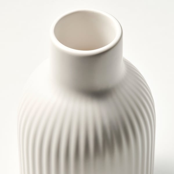 Elegant, tall, off-white vase with grooved texture. Matte finish, cylindrical shape, ideal for long-stemmed flowers.