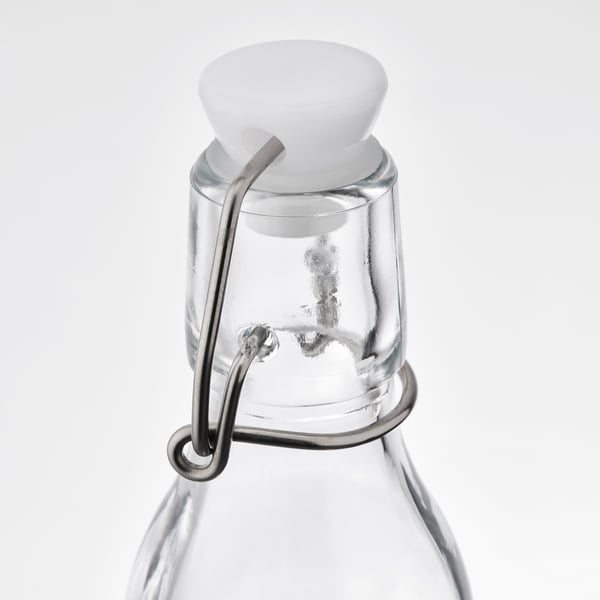 Glass bottle with white lid and metal clamp. Airtight seal for freshness.