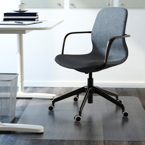 Office chair with height-adjustable seat and armrests, placed near a white desk with books and a mug.