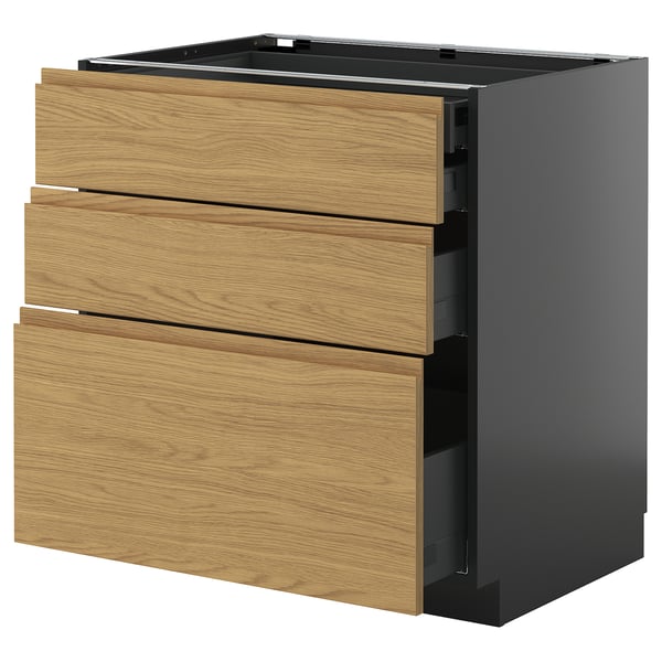 A modern kitchen cabinet with three wood-colored drawers, set against a dark gray frame. The design is minimalist and minimal.
