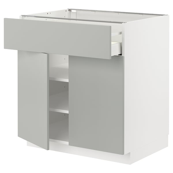 Modern white kitchen cabinet with single drawer and shelf.