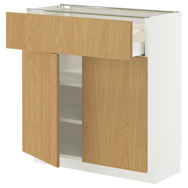 A white METOD kitchen unit with light wood drawers and shelves, featuring a modern design with a sleek and clean look.