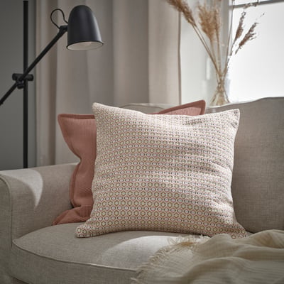 Cosy armchair with MOROTSMOTT pillow, peach pillows, beige blanket, and floor lamp.