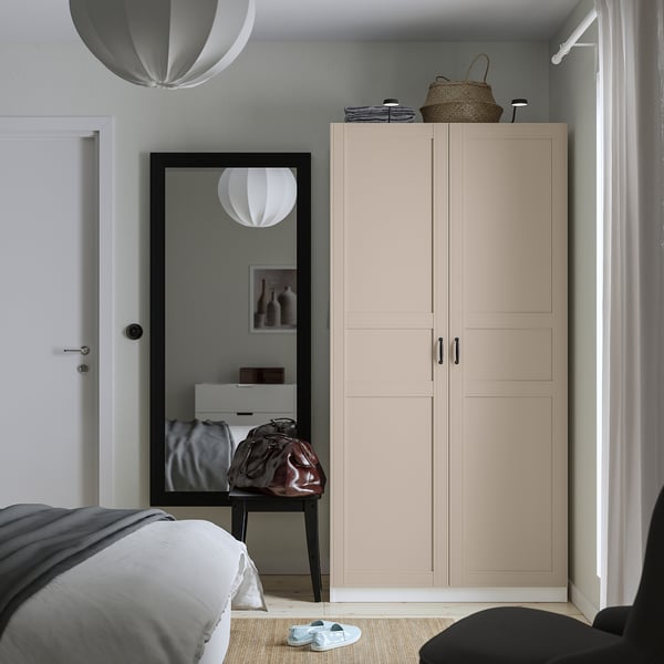 Modern bedroom with PAX wardrobe, mirror, table. Corner wardrobe, grey bedding, soft light, minimalist design.
