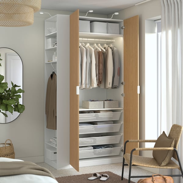 Organised wardrobe with drawers, clothes, and storage boxes; open doors show hanging space.