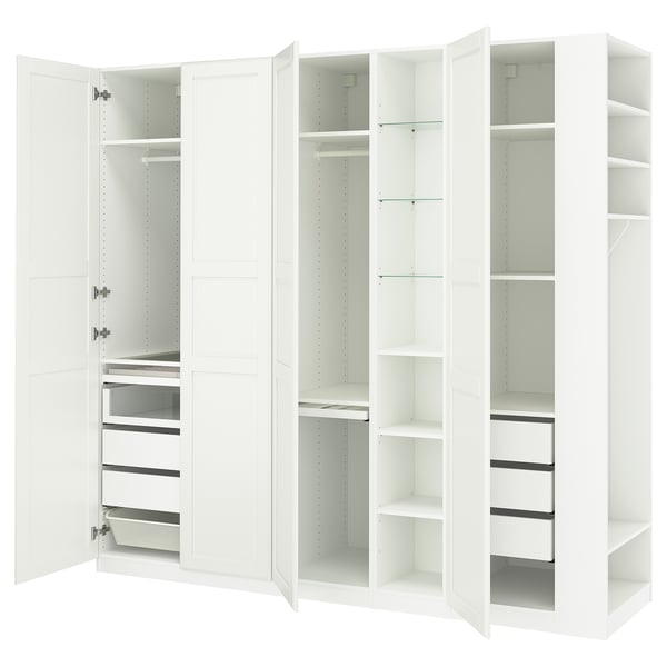 A white IKEA PAX wardrobe with open doors, revealing shelves and drawers inside.