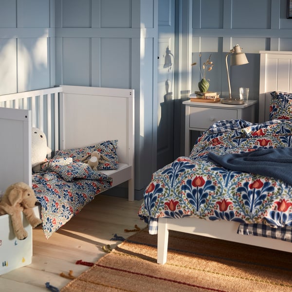 Childs bedroom with blue SÄTERVIDE bedding, teddy bear, toys, and sunlight.
