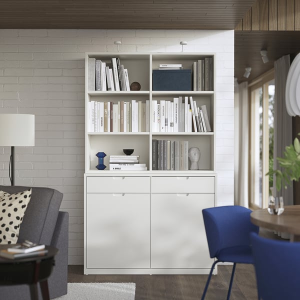 Modern white TONSTAD bookcase and sideboard in living room with grey chair, lamp, and blue chair.