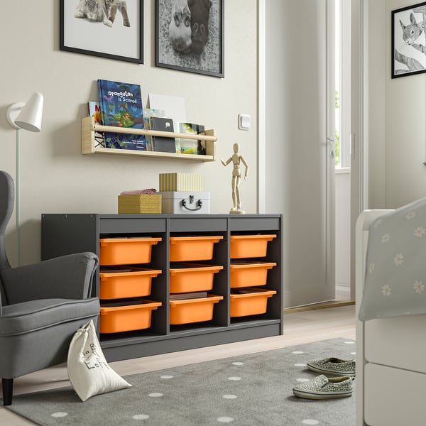 TROFAST storage in room with orange boxes, grey chair, white door, bookshelf, and lamp.