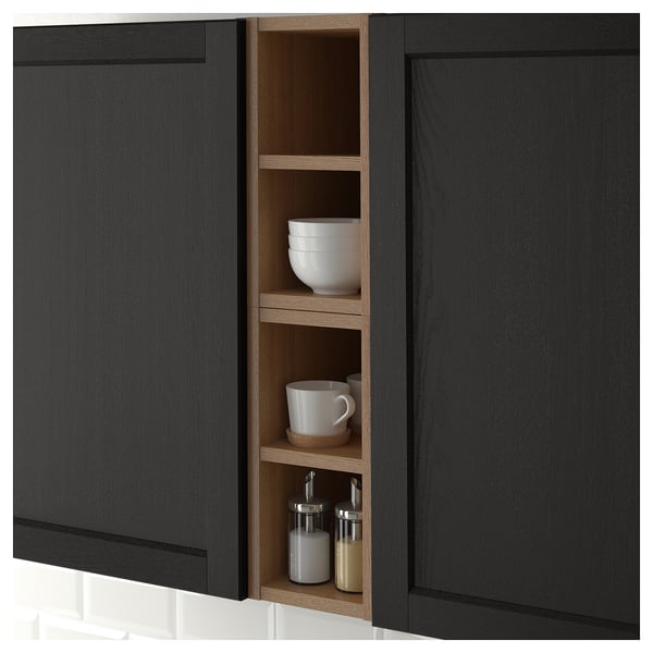 Black kitchen cabinet with open section holding white bowls, mug, and spice jars. Shows storage solution for easy access and display.
