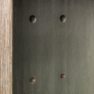 Four circular caps cover drill holes in a dark surface, making them less visible and giving a finished look.