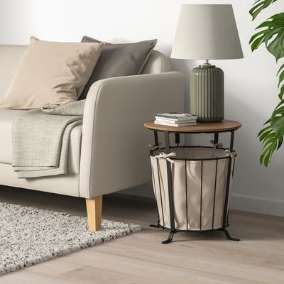 Angelsby side table beside sofa, rustic wood & metal, storage fabric bag, lamp & books.