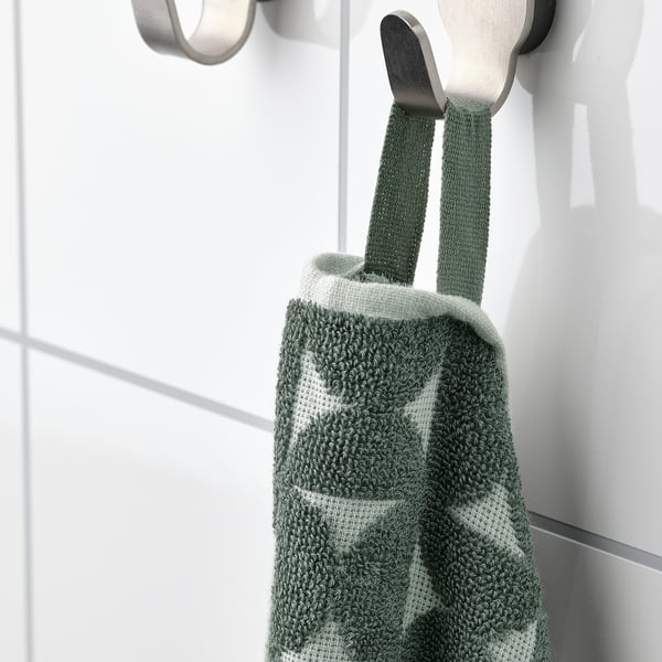 A green and white chequered towel hangs on silver hooks. Its terry back adds softness, while the patterned front offers style.