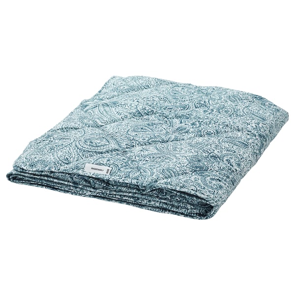 Folded blue-white patterned duvet, rectangular, printed floral design.