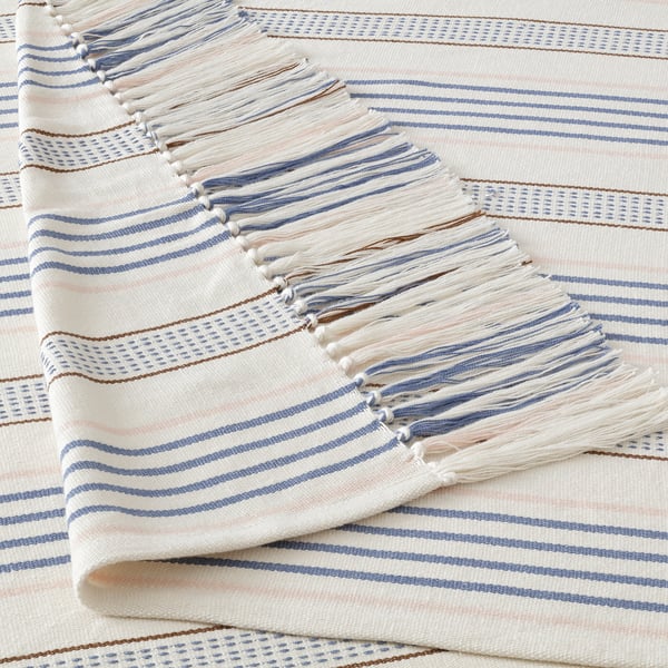Handwoven cotton throw with intricate fringes, showcasing striped patterns in soft blue and white tones, enhanced by delicate details.