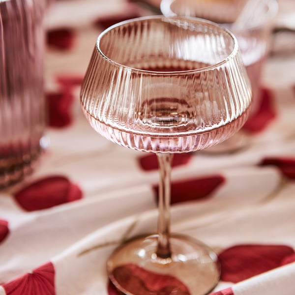 Elegant ANLEDNING champagne coupe, clear glass, wide bowl, stem base, festive drinkware.