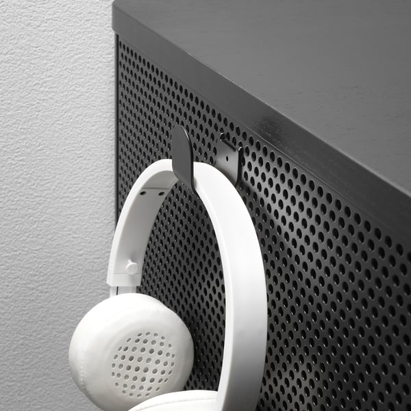 White headphones hang on metal hook of BEKANT storage unit.